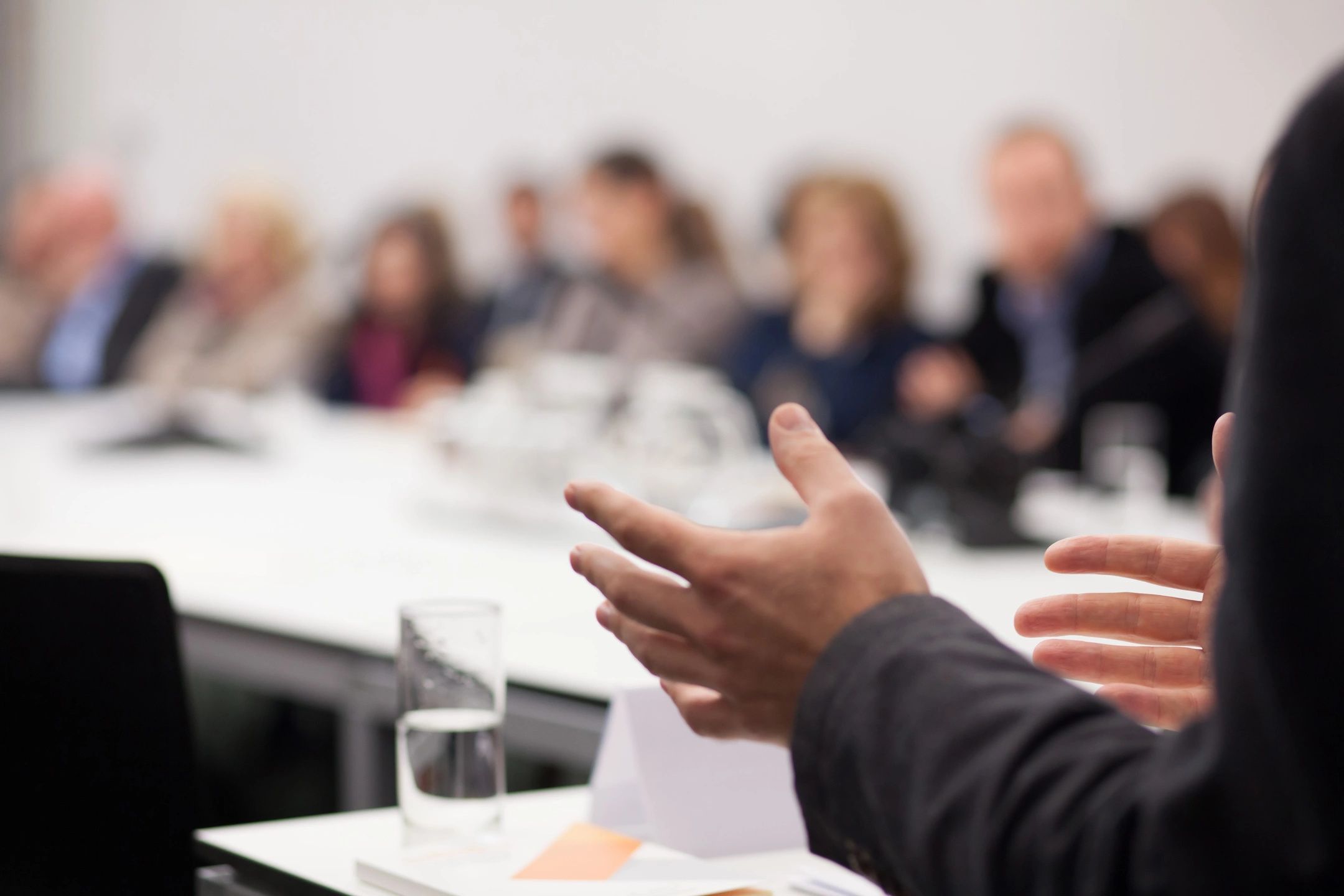 Person speaking around a conference table